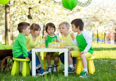 Kindergeburtstag im Garten feiern: Ideen für Deko, Spiele und Essen zum Nachmachen Kinder pusten Kerzen auf Torte aus
