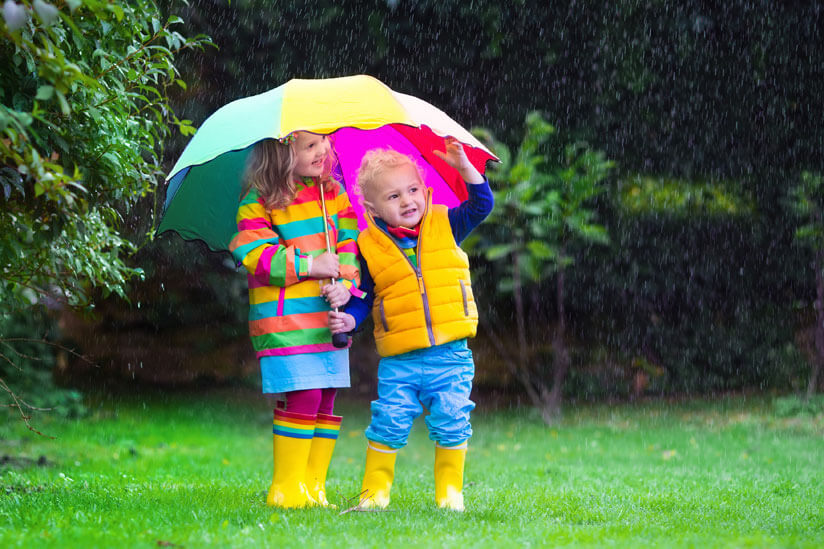 Kinder stehen unter Regenschirm
