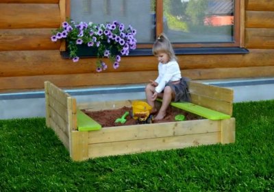 Sandkasten selber bauen: Das sollten Sie zur DIY–Sandkiste wissen! Kind spielt im Sandkasten