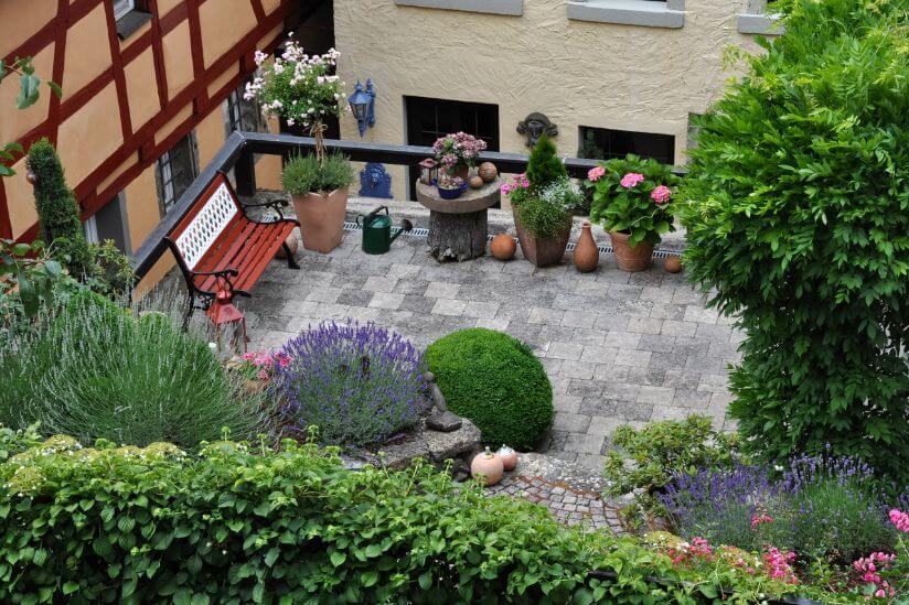Dachgarten anlegen: So begrünen Sie Ihre Dachterrasse (mit Anleitung)! Dachgarten mit Pflanzen und Ausblick auf umliegende Gebäude